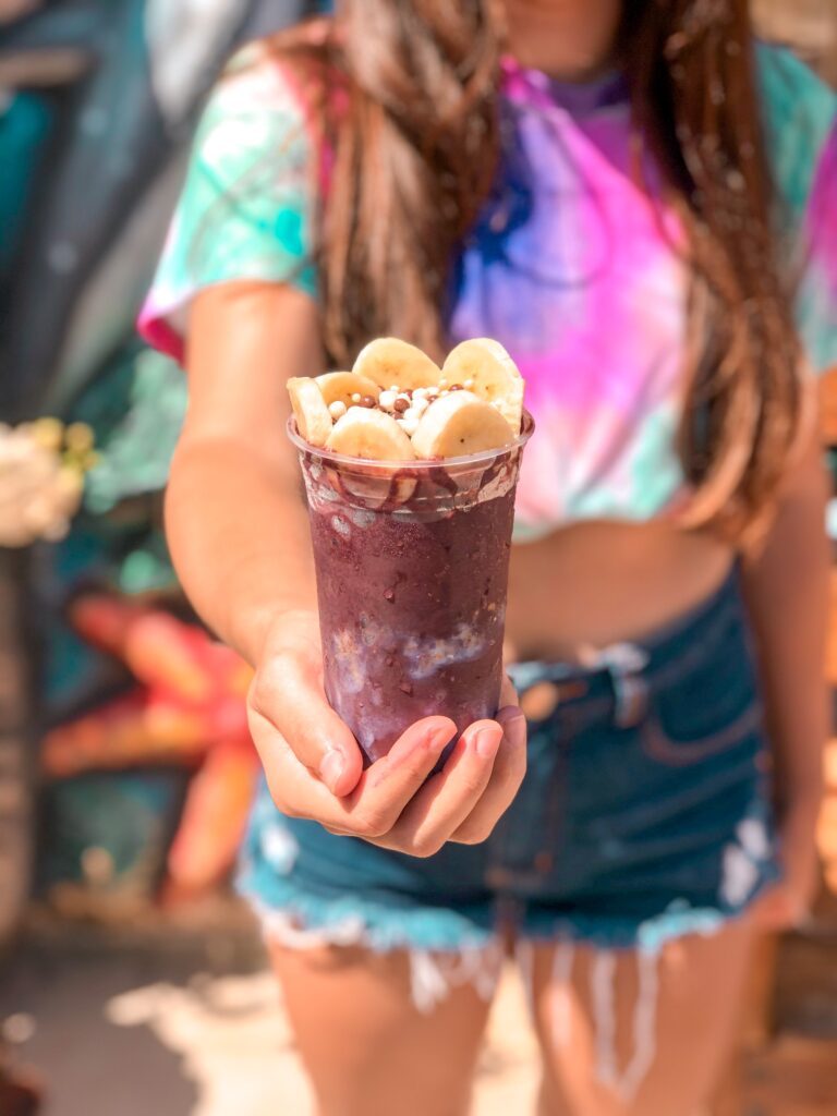 Brasilianische Acai gefroren in einem Plastikbecher mit Banane und Müsli
